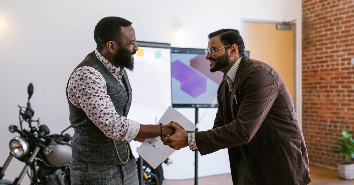 Transmission d'entreprise : un dirigeant et son repreneur en discussion dans l'atelier
